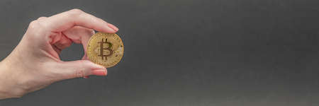 bitcoin in hand, female hand holds a gold bitcoin coin. Cryptocurrency value, digital money, space...