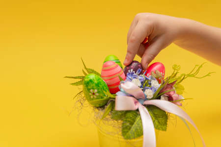 Easter bouquet, postcard for printing, gift bouquet in a bucket for Easter. Childrens hand makes a decorative bouquet on a yellow background. Place for textの写真素材