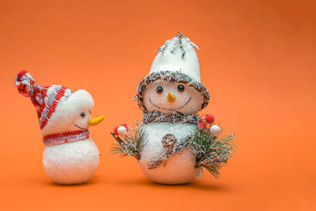 Christmas card, Happy New Year greetings. Snowman on an orange background, place for text. Christmas or New Years concept. Copy space.の写真素材