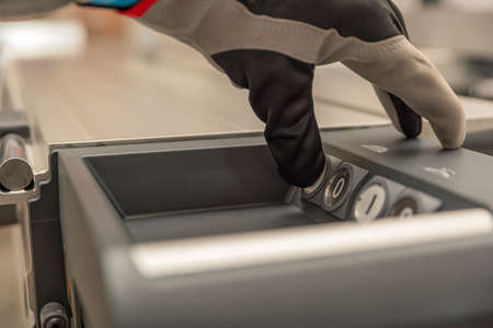Turns on the woodworking machine, the hand of the carpenter starts the woodworking machine....