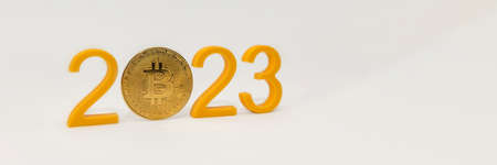 Bitcoin price prediction for 2023, cryptocurrency value in 2023. Yellow numbers and bitcoin coin on white backgroundの写真素材