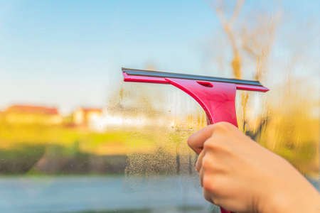 Condensation drops on the window. woman removes condensation from window panes. Cold season....
