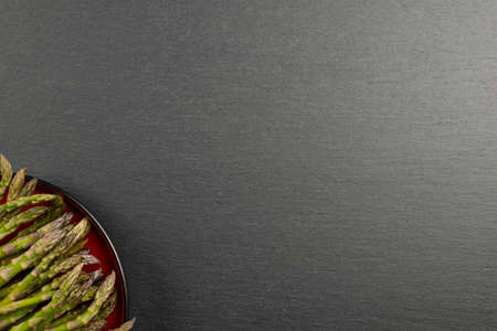 Green asparagus. Asparagus on a black slate stone background. View from above. Culinary banner with place for text. Large format for printingの写真素材