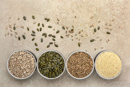 Various seeds on a marble background. Assortment, seeds set, healthy food ingredients, superfoods,...