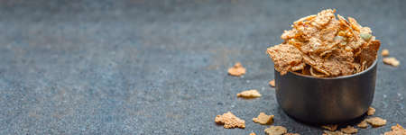 Dry muesli in a saucer on the background of a stone table top. Healthy food and light diet breakfast...