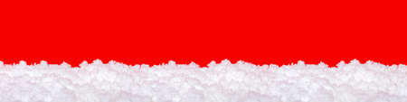 Snow on a red background. Christmas theme, large format, panoramic photo for a banner or website header. Christmas greeting card for printing.の写真素材