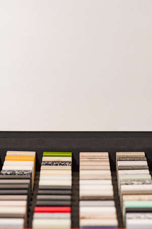Large selection of stone samples for countertops and floors. Pieces of artificial acrylic stone in a sample box. A set of shades of countertops of different texturesの写真素材