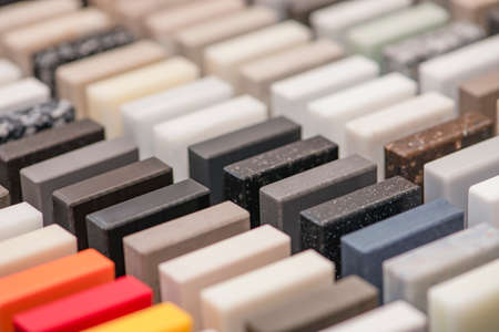 Large selection of stone samples for countertops and floors. Pieces of artificial acrylic stone in a...