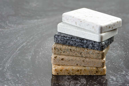 Large selection of stone samples for countertops and floors. Pieces of artificial acrylic stone in a sample box. A set of shades of countertops of different texturesの写真素材