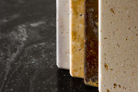 Large selection of stone samples for countertops and floors. Pieces of artificial acrylic stone in a sample box. A set of shades of countertops of different texturesの写真素材