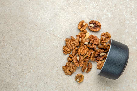 Walnut. Walnut fruits lie in a wooden saucer. Nearby are green leaves and unripe walnut fruits....