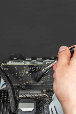 Cleaning dirty computer. Computer maintenance. Cleaning a dirty computer from dust with a special brush close-up. Place for your text. Banner for advertising and website header.の写真素材