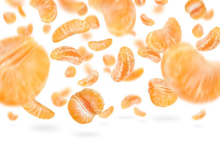 A large set of mandarin slices isolated on a white background falling down casting a shadow. Separate tangerine slices to insert into a project or designの写真素材