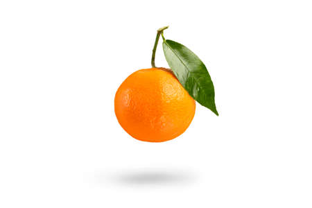 Tangerine with green leaf falls casting a shadow .Fresh tangerine on a white isolated background....