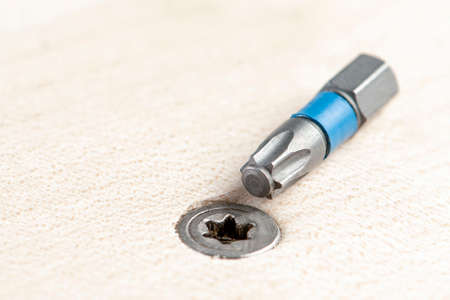 Screw the screw into the board. Furniture production, a screwdriver twists a self-tapping screw into...