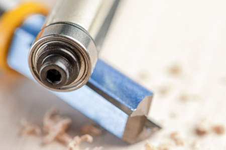 Copying the router bit. Cutter for trimming wooden edges. Copy-milling tool with steel bearing. Cutters lie on wood shavingsの写真素材