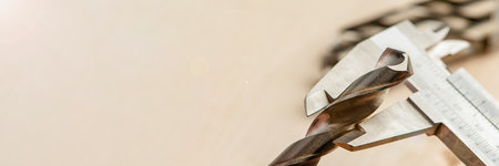 caliper measures drill bit on metal, measurement of thickness of drilling tool in industrial drilling machine. Metalworking industry.の写真素材