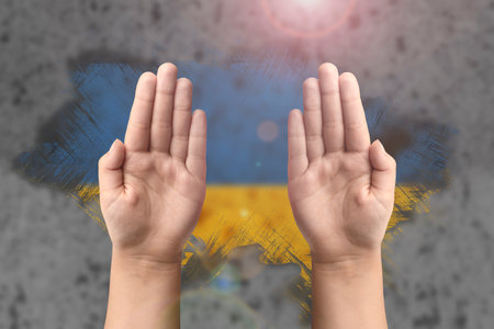 Support for Ukraine and solidarity. Childrens hands on the background of the Ukrainian flag. The concept of confrontation and struggleの写真素材