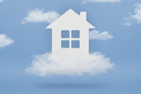 Dream House. The concept of buying a dream home. White house in the clouds on a blue sky background. Purchase of real estate, real estate loan.の写真素材