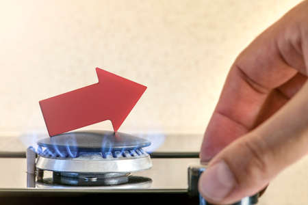 Gas price. Supply chains and the energy gas crisis. Gas stove with a burning flame and a graph arrow...