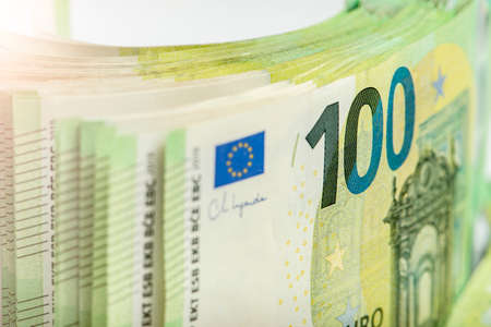 Close-up of a stack of paper bills, side view. Euro banknotes stacked on top of each other. Big pile...