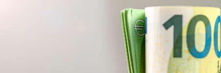 Roll of money. Roll of 100 euro banknotes. Euro banknotes rolled up on a gray background. The...