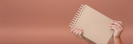 Notepad in hand. Blank notepad in the hands of a child on a red background. Hands hold a book...