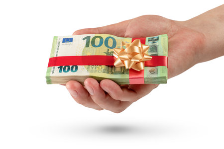 Gift of money. A pack of 100 euro bills in a male hand is isolated on a white background. Money gift concept for birthday or christmas.の写真素材