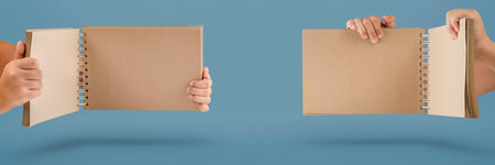 Notepad in hand. Blank notepad in the hands on a blue background. Hands hold a book without text....