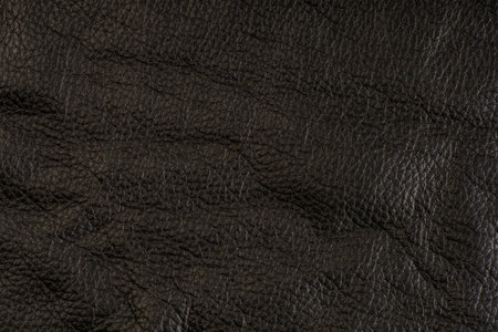black leather texture, close-up of black genuine leather. Leather top view in folds and bumps.