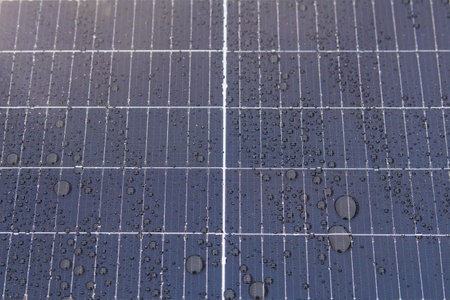 Green energy. Solar panels with raindrops close up. The use of waterproof solar panels in difficult...