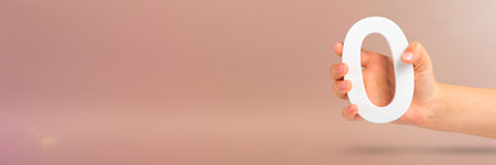Numeral zero in hand. A hand holds a white number zero on a red background with copy space. Zero concept, 0 percent interest rate, minimum air emissions, cost or credit no increase.の写真素材