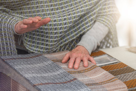 An elderly woman sells knitted items of her own production. Small business concept.