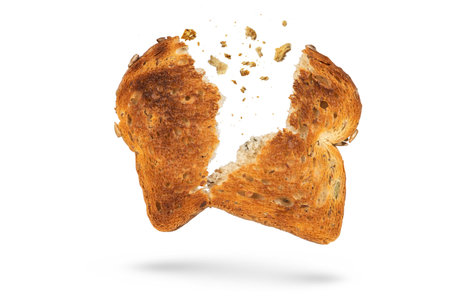 White bread slice isolate broken into 2 pieces with flying crumbs. Toaster fried bread isolated on white background. The concept of a small, dietary crispy breakfast.の写真素材