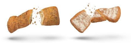 Two loaves of crispy bread isolated on white. Loaves of freshly baked crispy bread are broken in half with crumbs flying in all directions at the break. Top and bottom view. Fresh baking concept.の写真素材