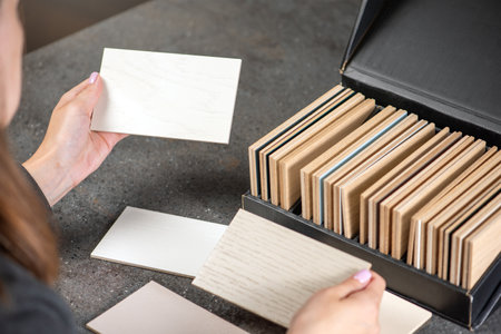 A woman holds samples of different shades for the floor in her hands, or chooses it from a designer...