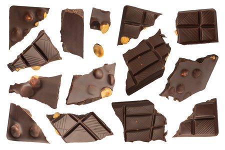 Milk chocolate with nuts. Slices of chocolate with nuts on a white isolated background. Milk chocolate slices from different sides of different sizes are suitable for chocolate packaging labels.の写真素材