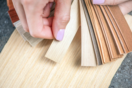 PVC edging samples close up. Womens hands hold samples of PVC edging in their hands. Components for...