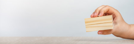 Wooden rectangles in hand. Wooden rectangle in hand with copy space on a gray background.の写真素材
