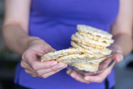A hand holds a bowl of corn chips close-up. The process of eating a quick snack in the form of corn chips.の写真素材