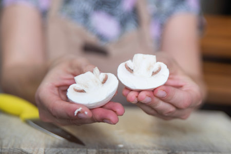 The process of peeling mushrooms. A womans hands peel mushrooms with a knife, close-up. Cooking mushrooms.の写真素材
