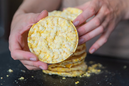 A hand holds corn chips close-up. The process of eating a quick snack in the form of corn chips.