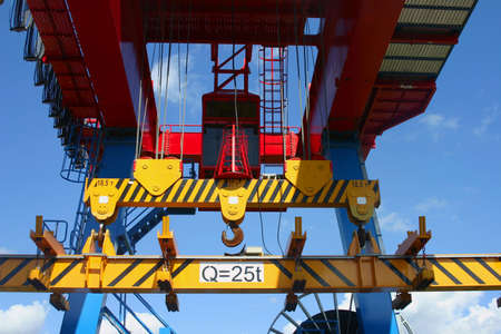 Red, yellow and blue Goliath crane loading of goods on clear blue sky background.の写真素材