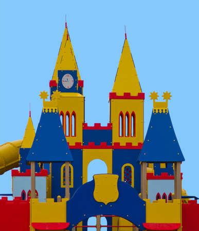 Children`s fortress from color panels with tower, windows, staircases and slides. Red, yellow, blue colors. Isolated over blue background.の写真素材