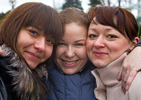 Three women stay together with another. Portraits. They are caucasian. Friends.