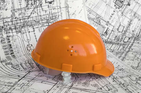 Orange helmet lies on the project drawingsの写真素材