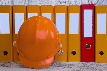 Yellow, red file folders, helmet are on the table. Business still-life. Clear place for your text.の写真素材