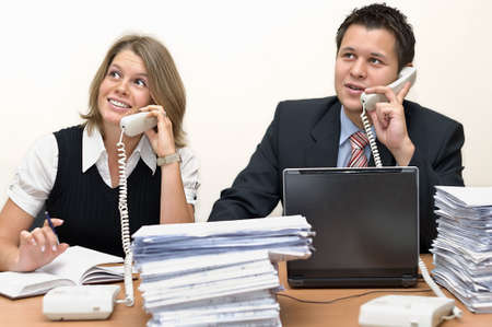 Happy young operators speaking by phone. On a white backgroundの写真素材