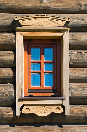 Ancient Russian window in timber wall of wooden houseの写真素材