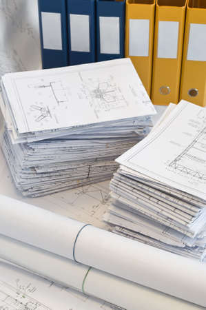 Big heapÑ‹ of design and project drawings in yellow folder on the table surface. White whatman...